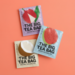 Three 'The Big Tea Bag' tea packages on a peach background